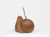 an image of a wooden sculpture of a pear on top of a white box