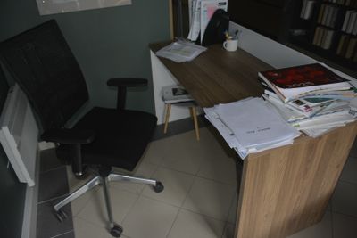 a desk with a computer and a chair in a room