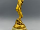 une image représentant une statue en or d'un homme posée sur un socle en marbre