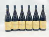 six bouteilles de vin sont alignées sur une surface blanche