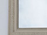 a mirror hanging on the wall with a sky in the background
