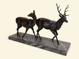statue représentant un couple de cerfs sur un socle en marbre, sur fond blanc