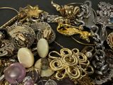 a pile of jewelry on a table with a black background