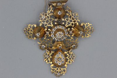 une croix en or et diamants sur laquelle est représenté un oiseau