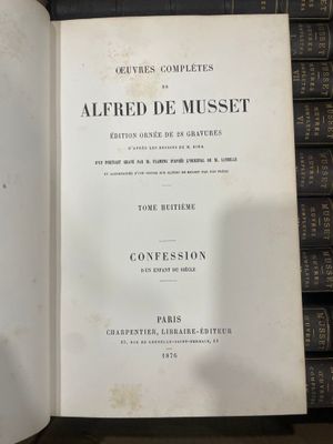 un livre ouvert posé sur une table à côté d'une pile de livres
