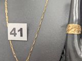 Collier à chaîne en or et bague présentés sur un mannequin, avec étiquette de prix