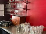 bottles and glasses are lined up on a counter in a kitchen