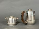 pair of silver plated teapots with wooden handles and handles