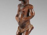 une image d'une statue en bois représentant un homme tenant un bébé
