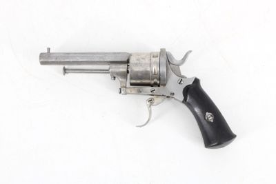 an old revolver with a black handle on a white surface