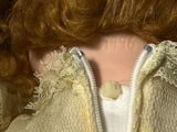 a close up of a doll ' s face with red hair