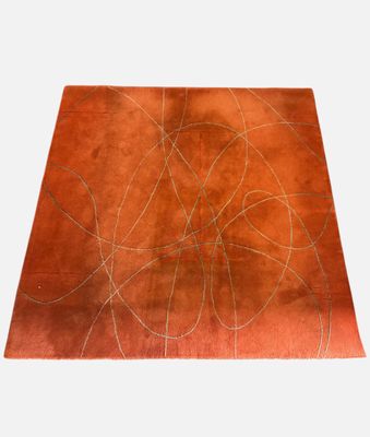 an orange rug with a design of circles and lines on it
