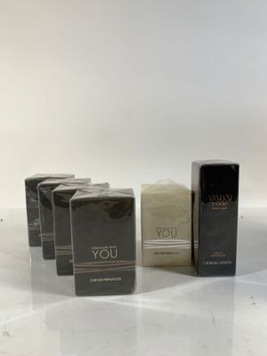 three boxes of perfume sitting on top of a white table