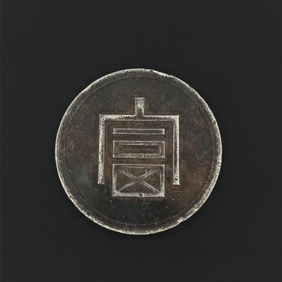 a close up of a silver coin with a chinese writing on it