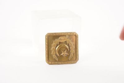une petite médaille en or ornée d'une étoile