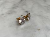 pair of diamond stud earrings sitting on a marble surface