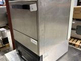 a silver ice machine sitting on top of a metal table
