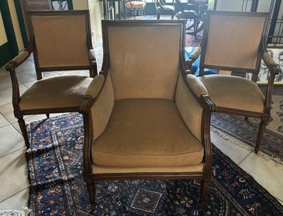 trois chaises posées sur un tapis dans une pièce