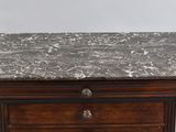 an old wooden chest of drawers with a marble top