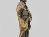 an old statue of a man holding a dog on a wooden base