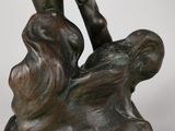bronze statue of a boy holding a fish on a rock