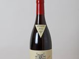 une bouteille de vin rouge posée sur une table en bois