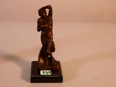 figurine en bronze représentant une femme tenant un panier, posée sur un socle noir