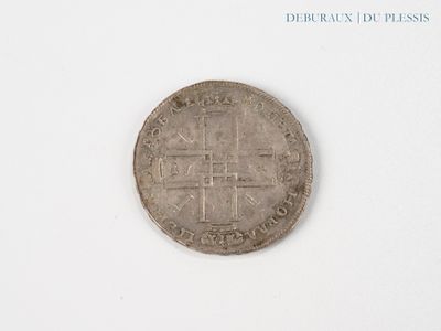 an old coin with a cross on it on a white surface
