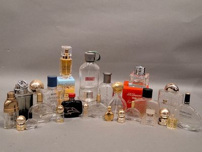 de nombreux flacons de parfum de styles variés posés sur une surface blanche