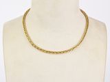 a close up of a gold necklace on a mannequin torso