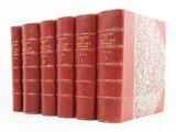 six red books are lined up in a row on a white surface