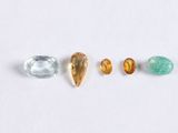 a group of three different colored gems on a white surface