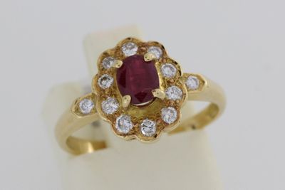 gros plan d'une bague en or avec un rubis et un diamant au centre