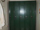 a green locker in the hallway of a building