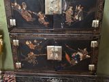 une commode noire ornée de motifs orientaux