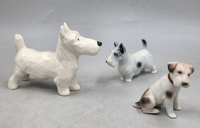 trois petites figurines représentant des chiens assis par terre