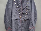 un vieux manteau militaire accroché à un cintre sur un mur