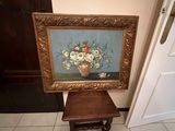 a picture of a vase of flowers sitting on a small table