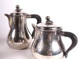 pair of antique silver plated teapots on white background