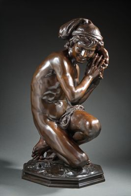 a bronze statue of a woman kneeling down with her hands on her face