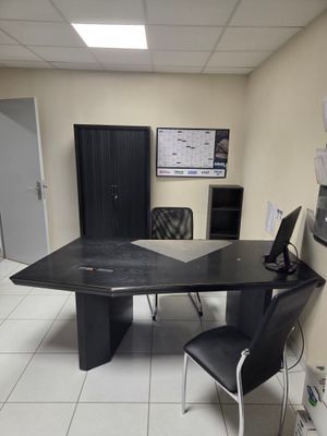 un bureau avec un ordinateur et une chaise dans une pièce