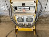 a yellow and white machine sitting on top of a cement floor next to a wall