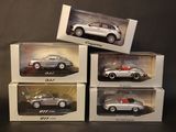 four different models of cars in boxes on a black surface