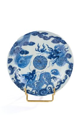 une assiette bleue et blanche ornée de deux poissons et de nuages