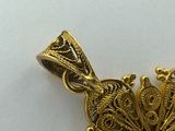 an image of a gold butterfly pendant on a white surface