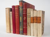 plusieurs vieux livres sont empilés sur une surface blanche