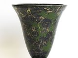 a black and green vase sitting on a white surface