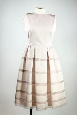 une robe blanche posée sur un présentoir à mannequin, sur fond blanc