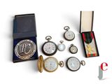 many different types of pocket watches and medals in a box
