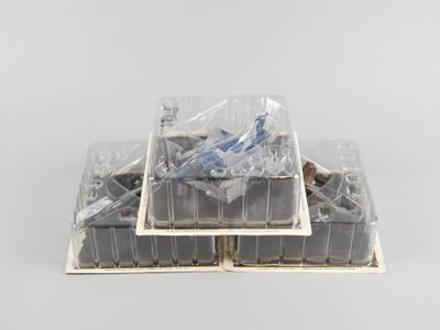 une pile de récipients en plastique remplis de nourriture posée sur une surface blanche